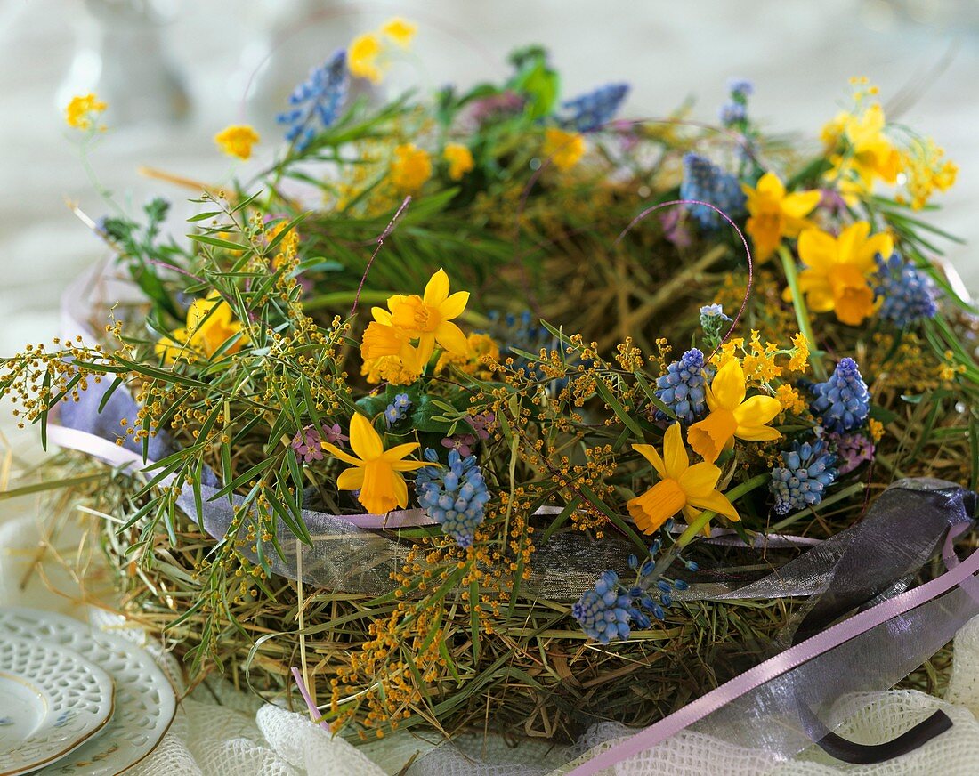 Kranz aus Heu, Narzissen, Traubenhyazinthen und Mimosen