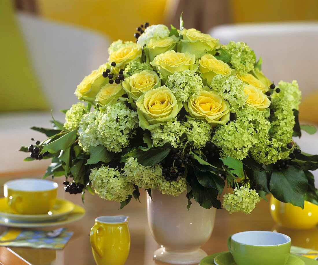 Arrangement of yellow roses with Viburnum