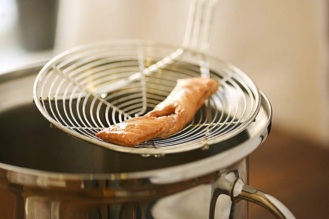 Lifting klenäter (Swedish fried pastry) out of oil