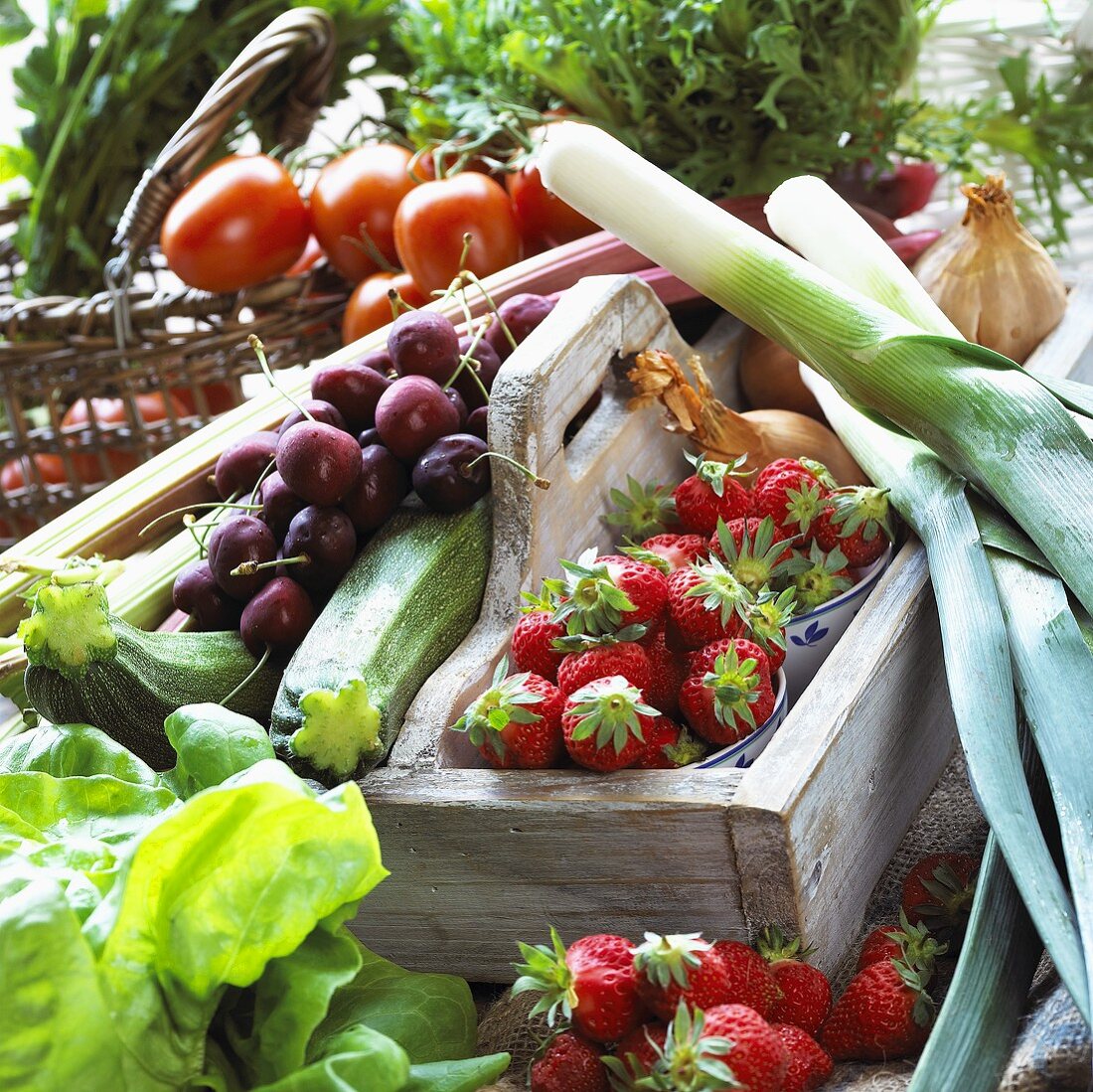 Sommerfrüchte und Gemüse in Steige und Korb