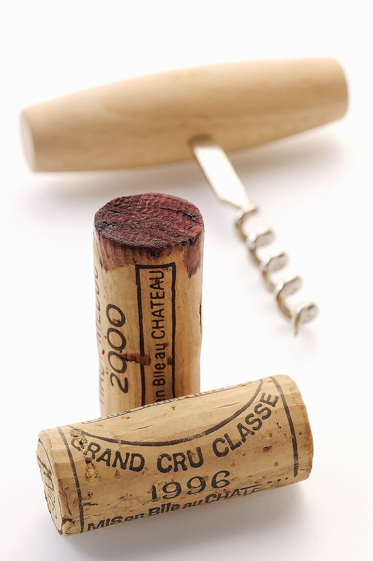 Wine corks from various vintages with corkscrew
