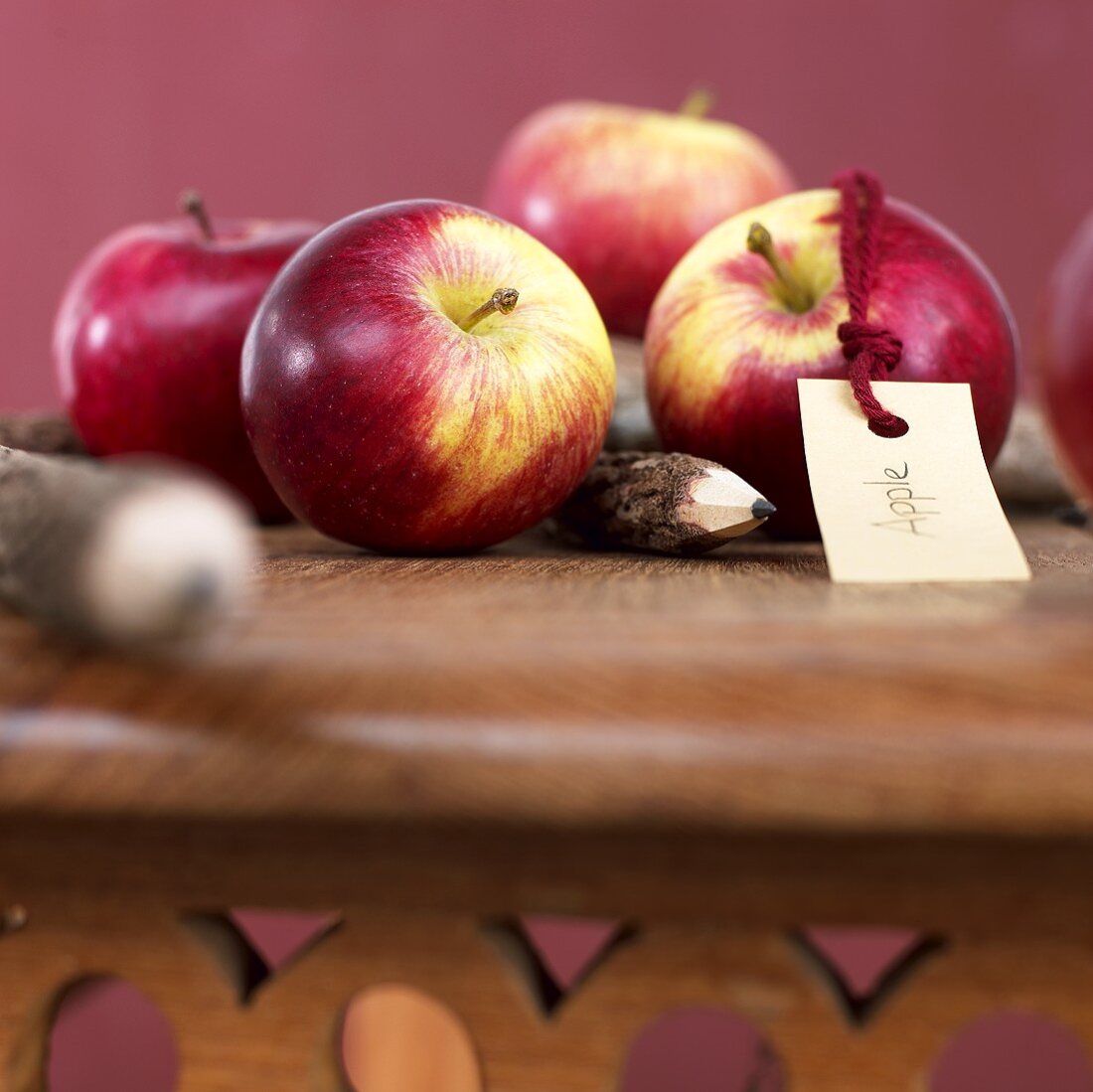 Äpfel und Bleistifte auf Holztisch