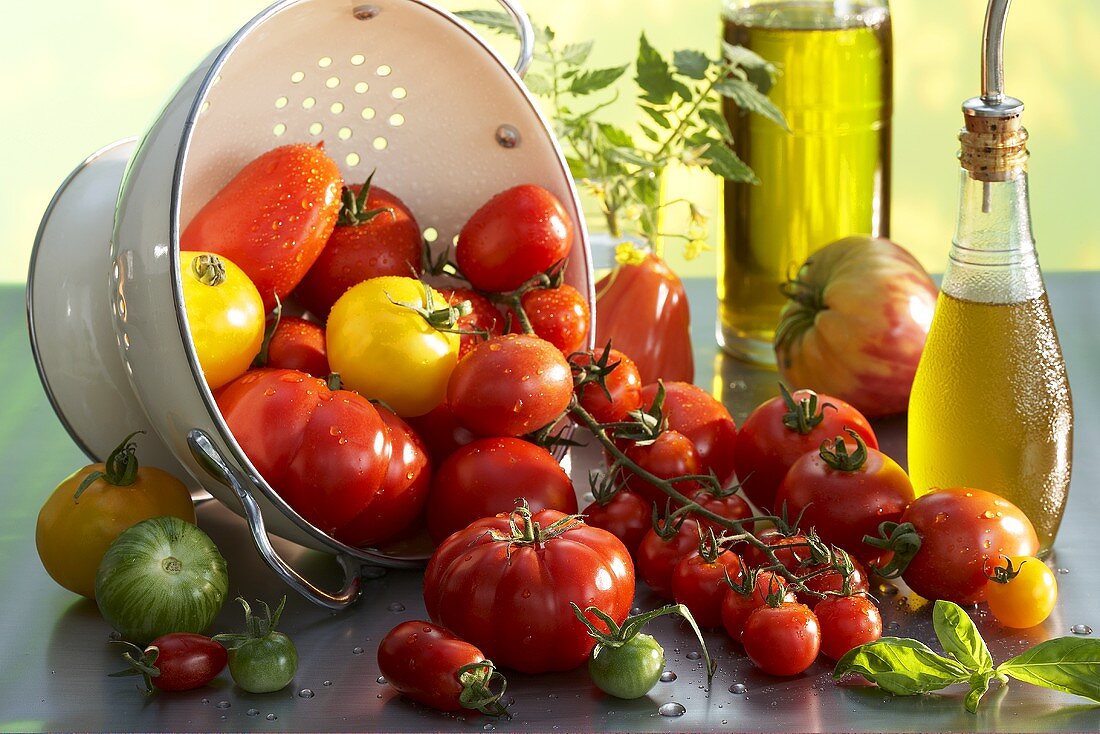 Various types of tomatoes with a colander
