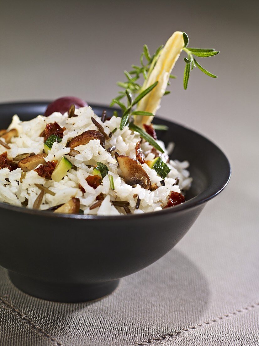 Rice dish with chestnut mushrooms, courgettes, black olives & dried tomatoes