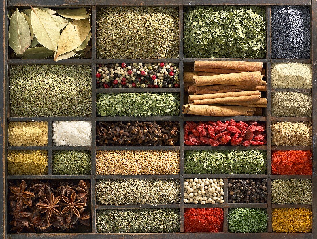 Various dried herbs and spices in type case (overhead view)