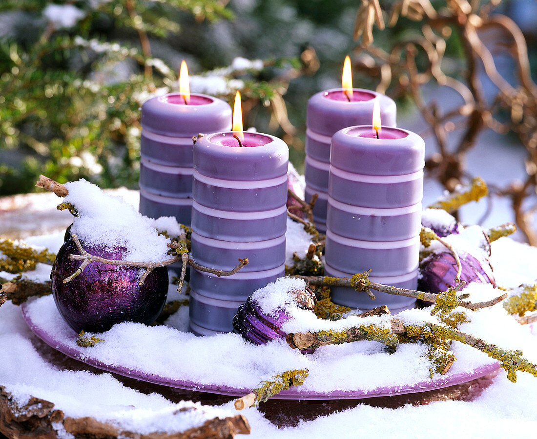 Advent arrangement with four candles and snow