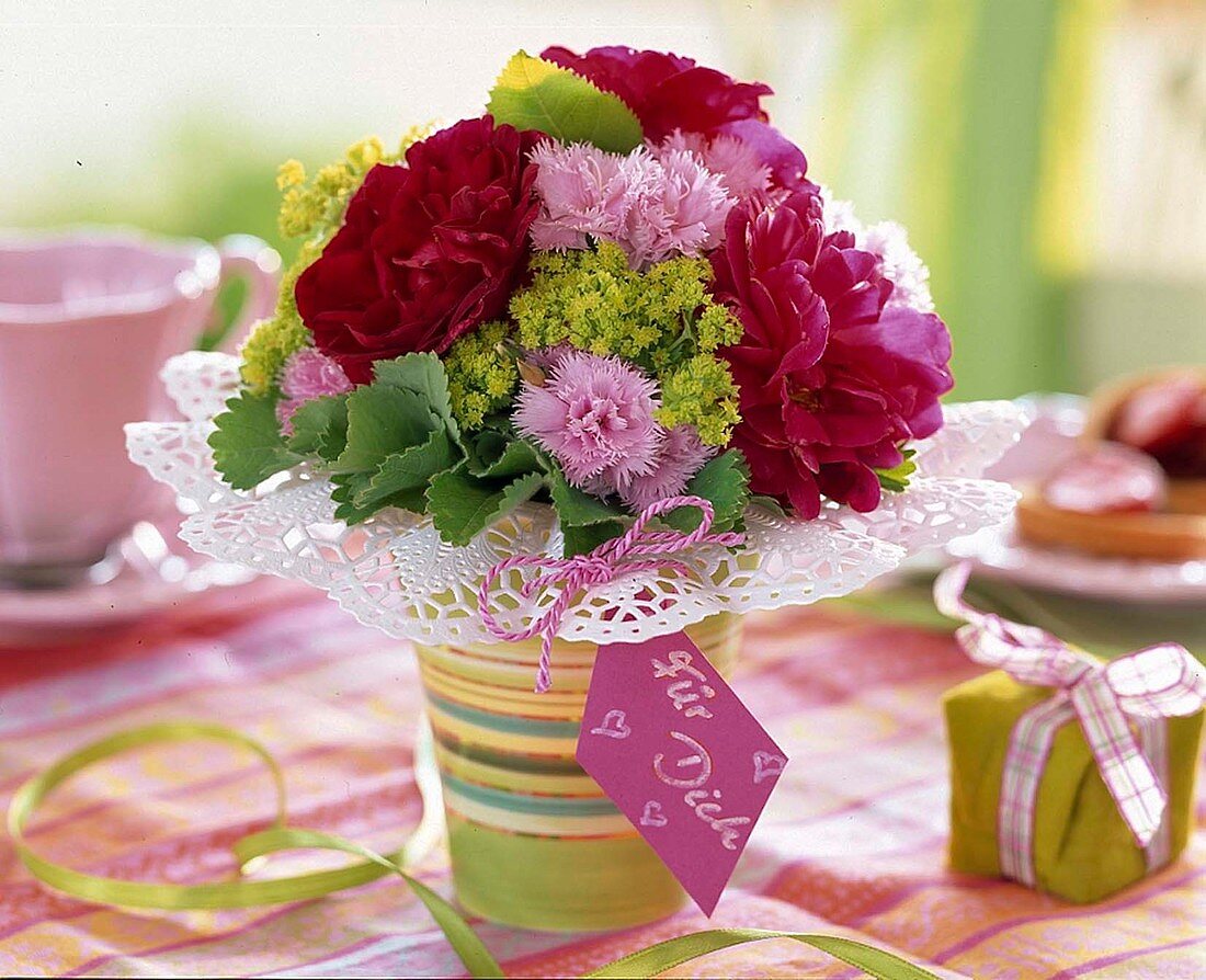 A posy of roses, pinks and lady's mantle with gift tag