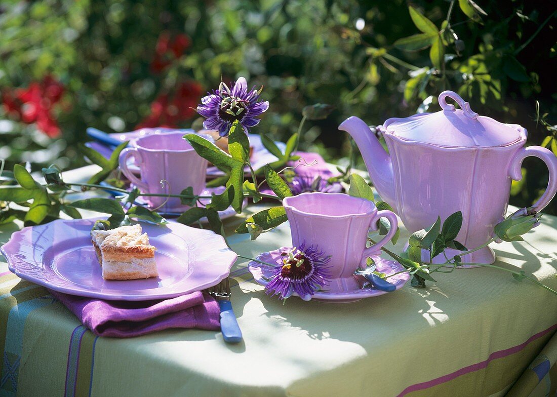 Table laid for coffee in open air with passion flowers