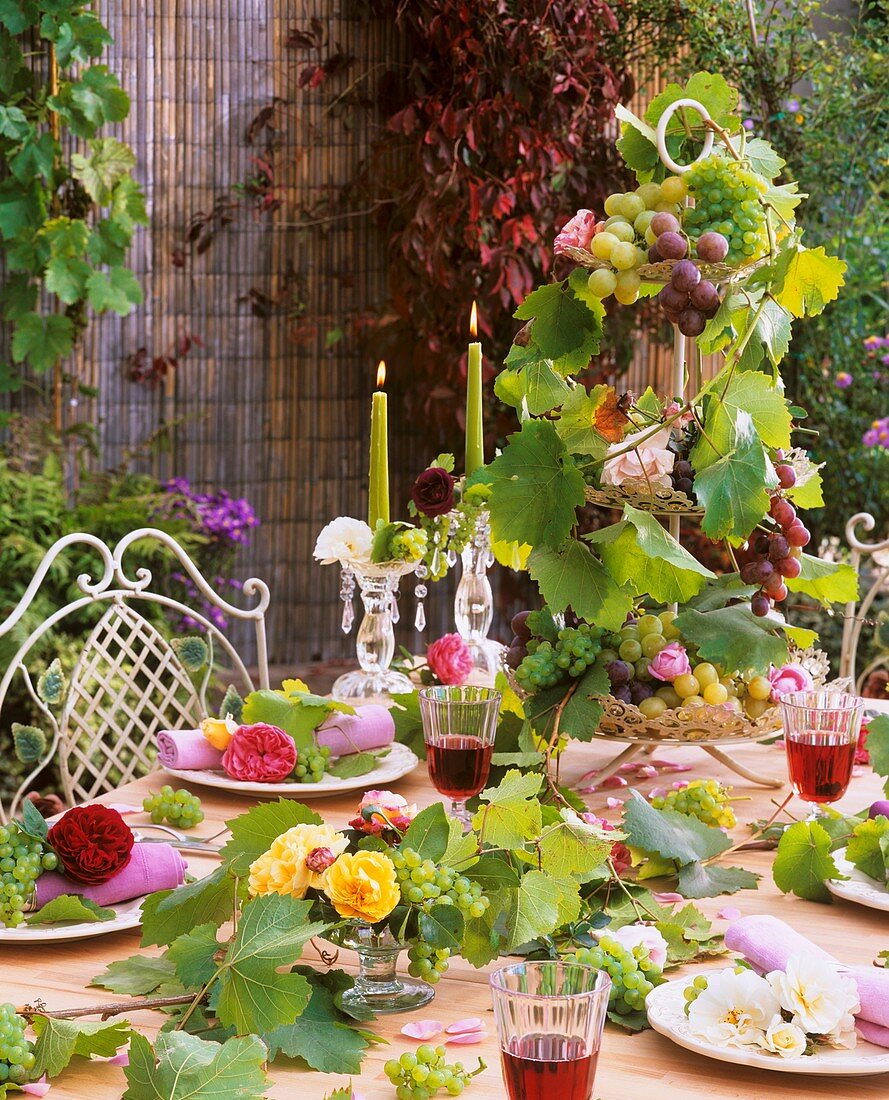 White, yellow, pink & red roses with grapes as table decoration