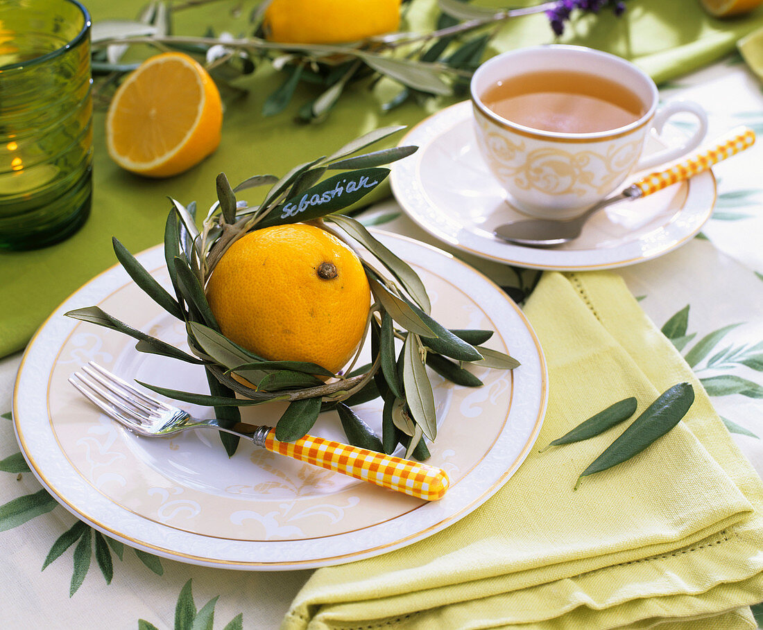 Ein mit Zitronen und Olivenzweigen gedeckter Tisch