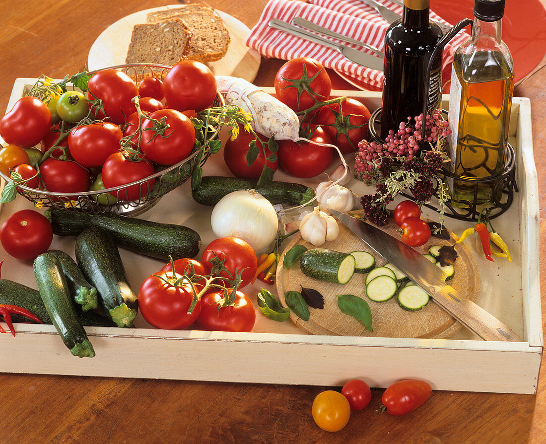 Tray with tomatoes, courgettes, onions, vinegar and oil