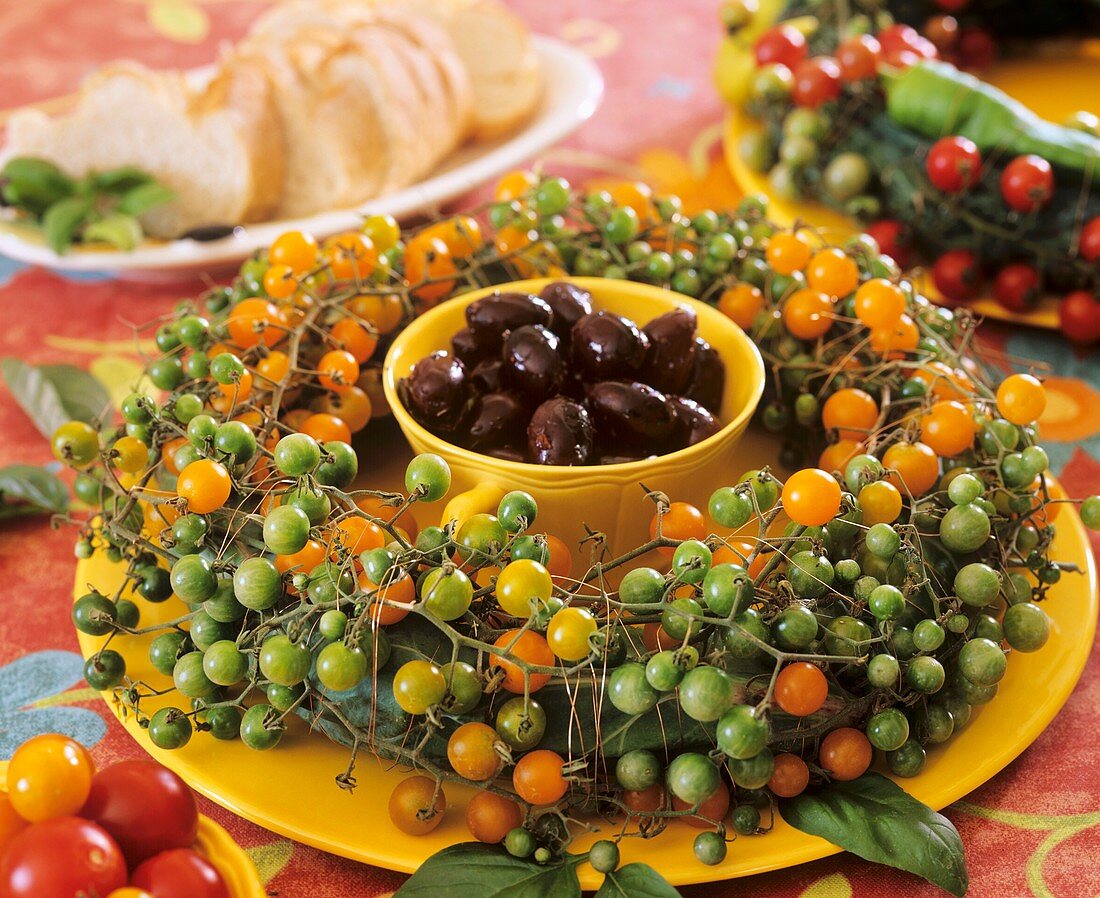 Olives surrounded by a wreath of cocktail tomatoes
