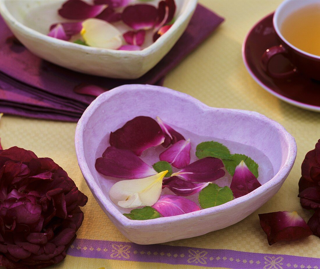 Table decoration of rose petals in a heart-shaped bowl