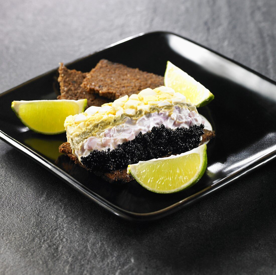 Terrine mit Kaviar, Avocado, Frischkäse, Ei auf Vollkornbrot