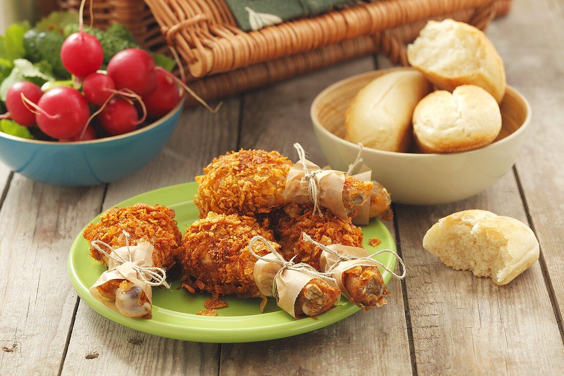 Chicken drumsticks, radishes and bread rolls for a picnic