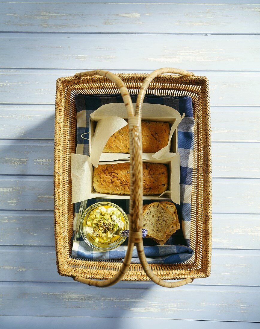 Picknickkorb mit Zucchinibrot und Avocado-Ziegenkäse-Dip