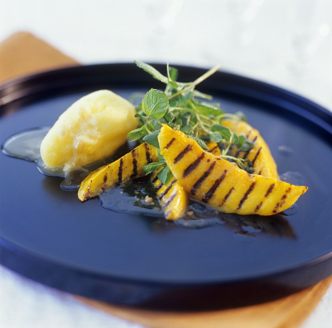 Grilled mango slices with mango sorbet and mint