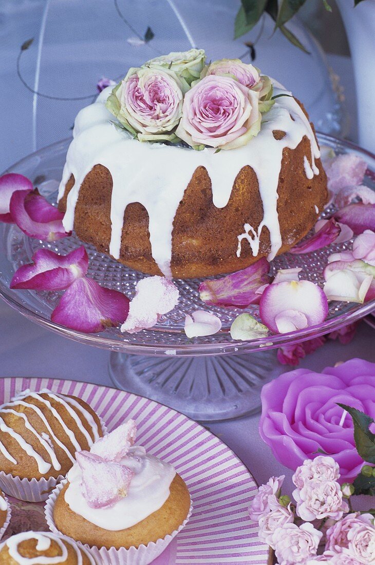 Muffins und Gugelhupf mit Zuckerglasur und Rosen