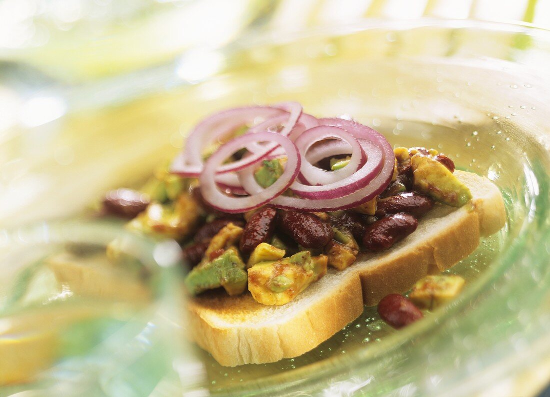 Slice of bread topped with avocado and bean salad