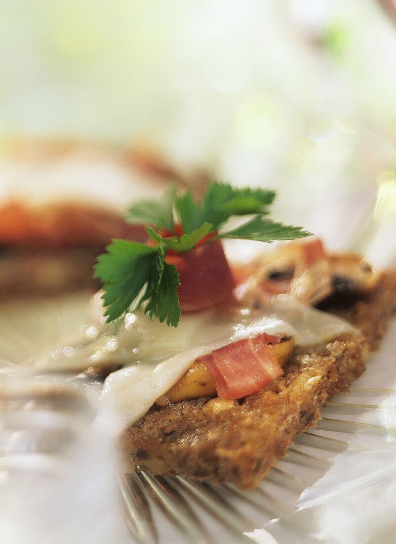 Brotscheibe mit Pilzen, Gänsebrust und Ziegenkäse überbacken