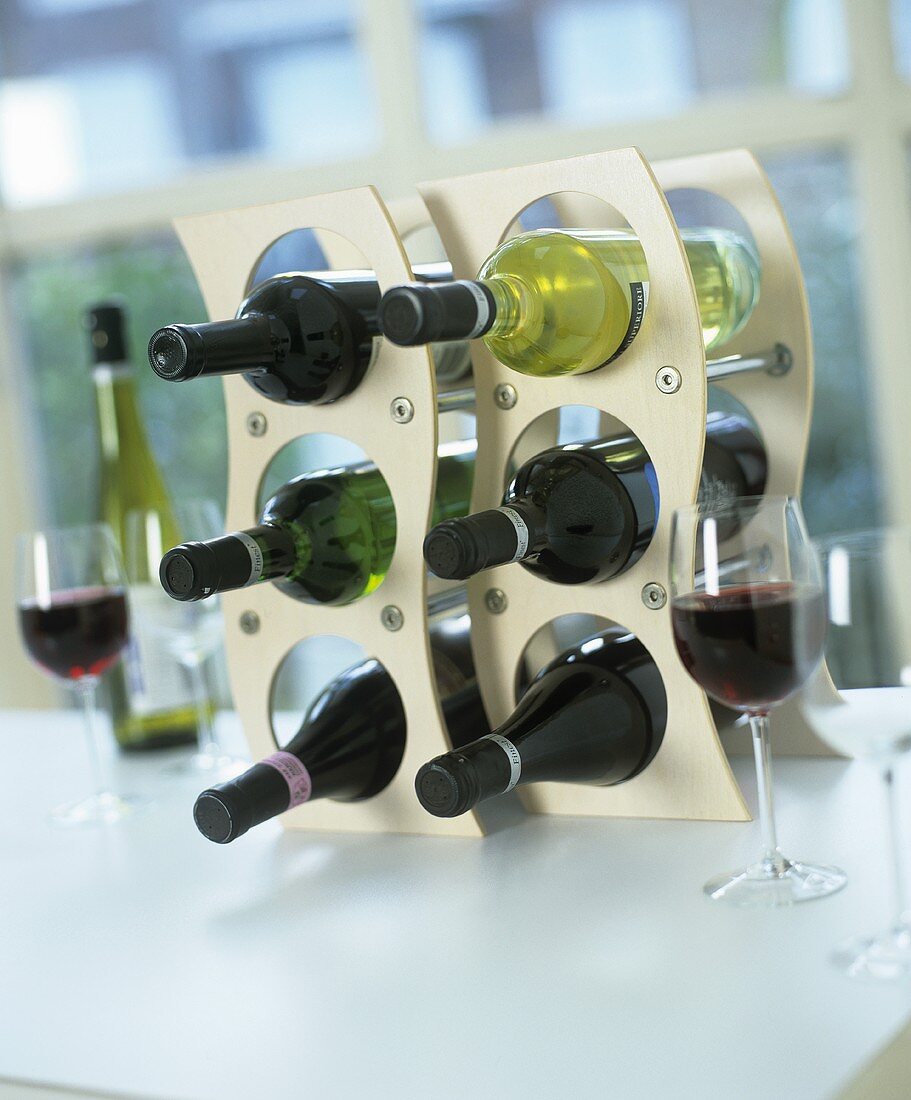 Weinregal mit Rotwein- und Weissweinflaschen und Weingläser