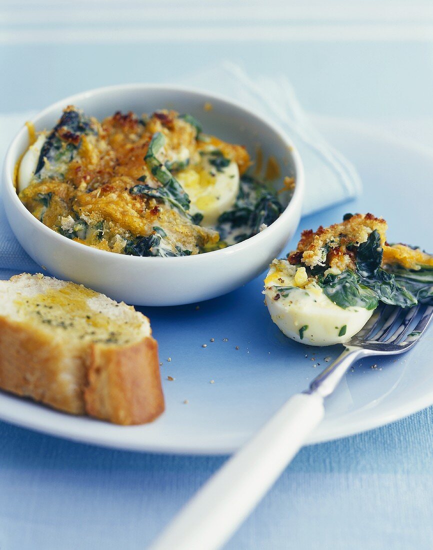 Boiled eggs baked in the oven with spinach & cheese topping