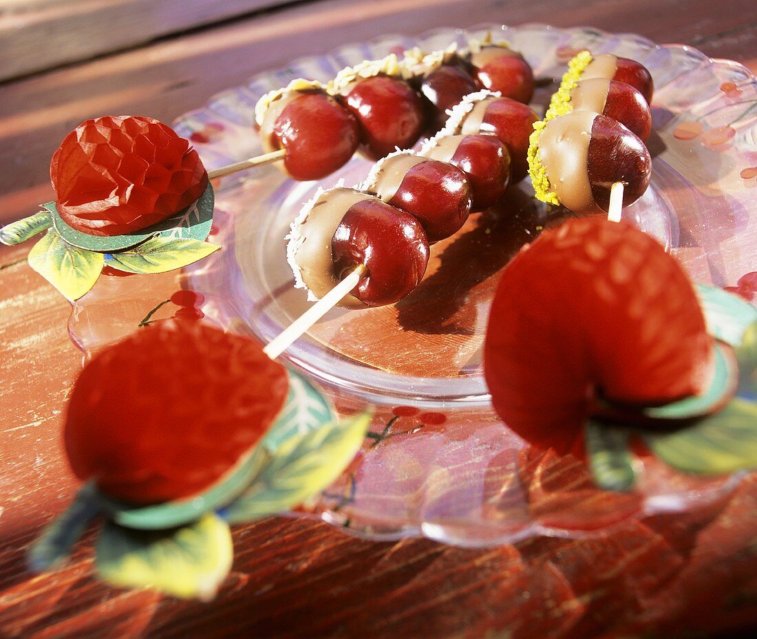Skewered cherries dipped in chocolate, coconut & pistachio