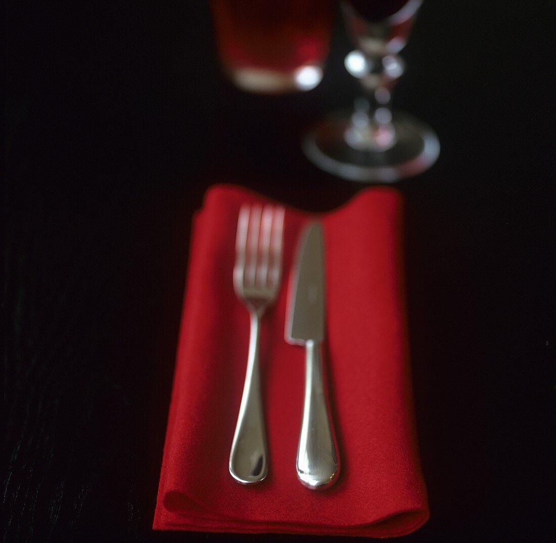Knife and fork on red napkin