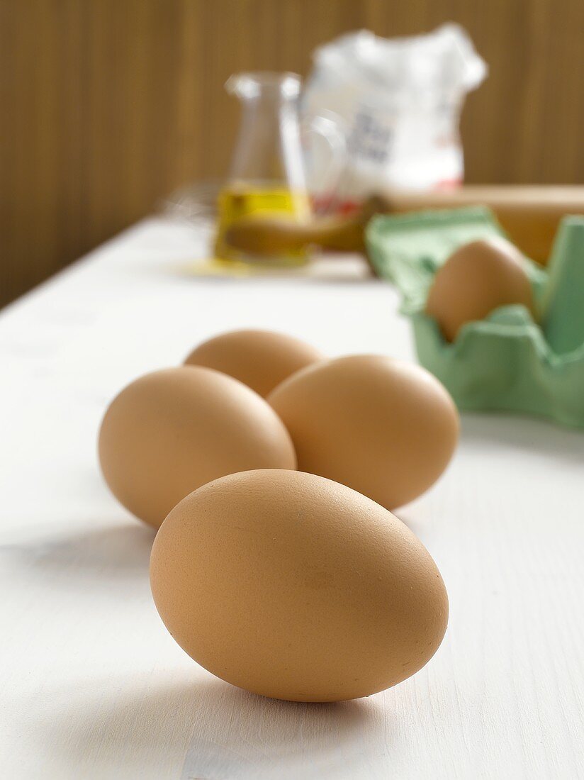 Eggs, rolling pin, oil and flour in background