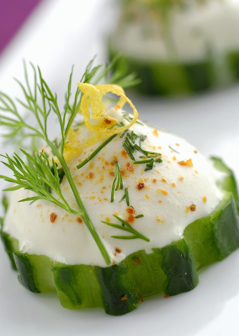 Cucumber appetisers with sour cream and dill (close-up)