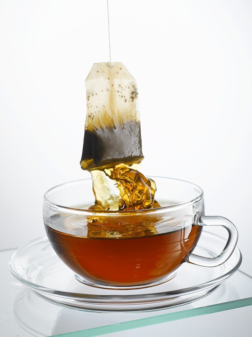 Taking tea bag out of cup