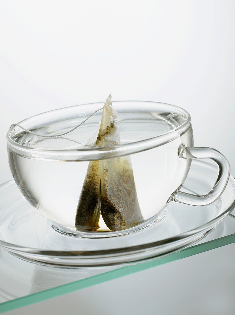 Hot water and tea bag in glass cup