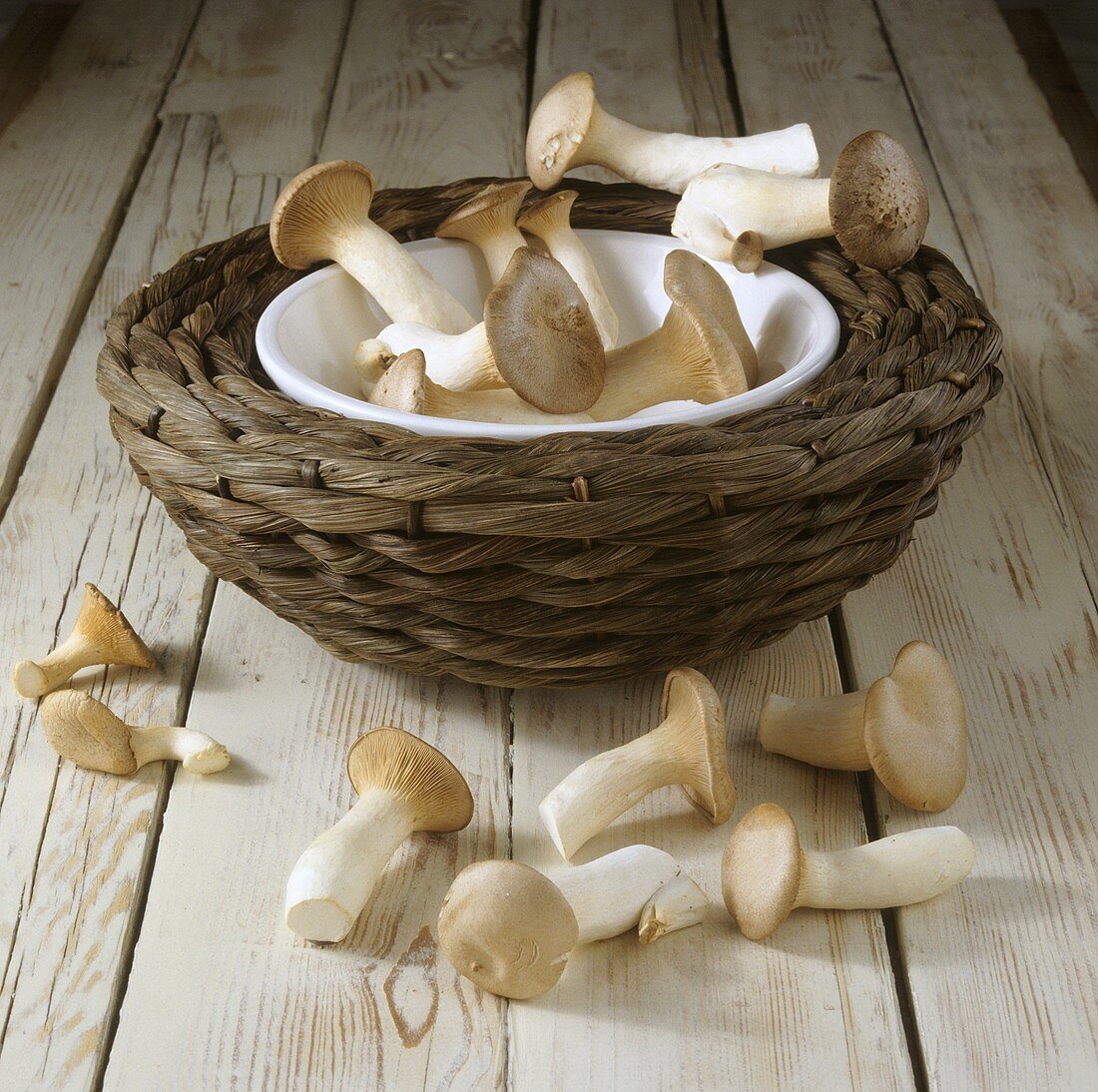 King oyster mushrooms in and in front of woven basket