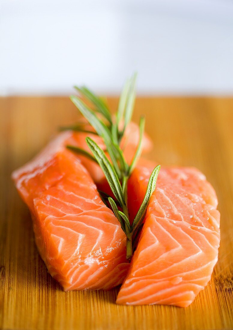 Fresh salmon with rosemary on a wooden board