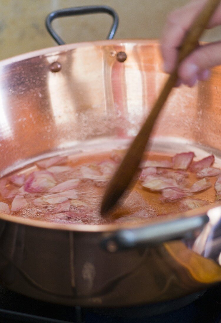 Rosenkonfitüre in einem Kupfertopf kochen