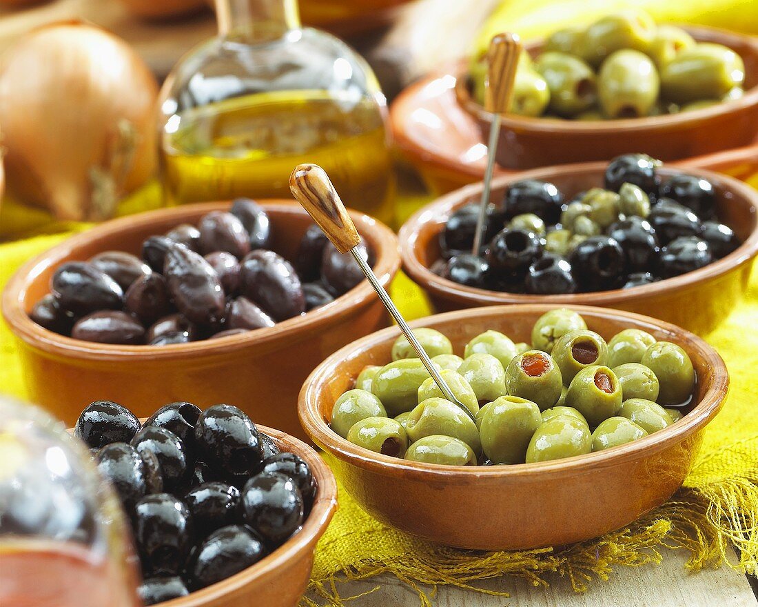 Various types of olives in terracotta dishes