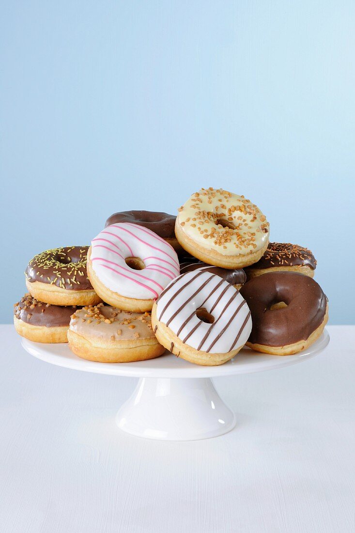 Donuts mit verschiedenen Glasuren auf einer Kuchenplatte