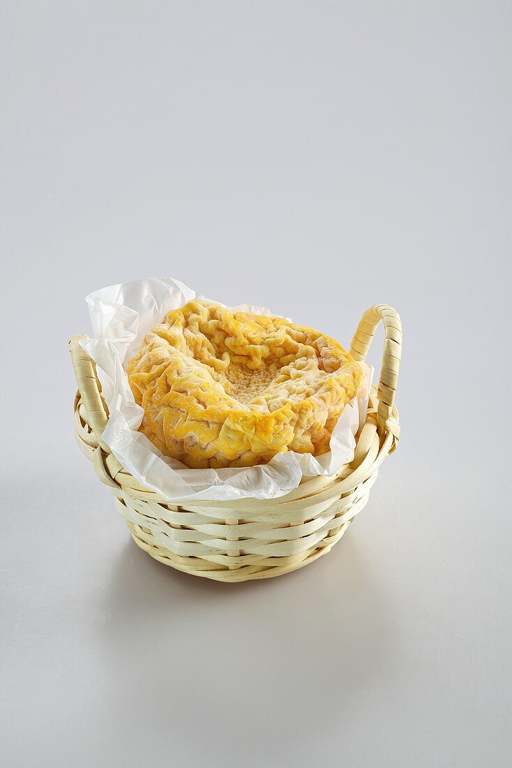 Langres (washed rind cheese from France) in a basket