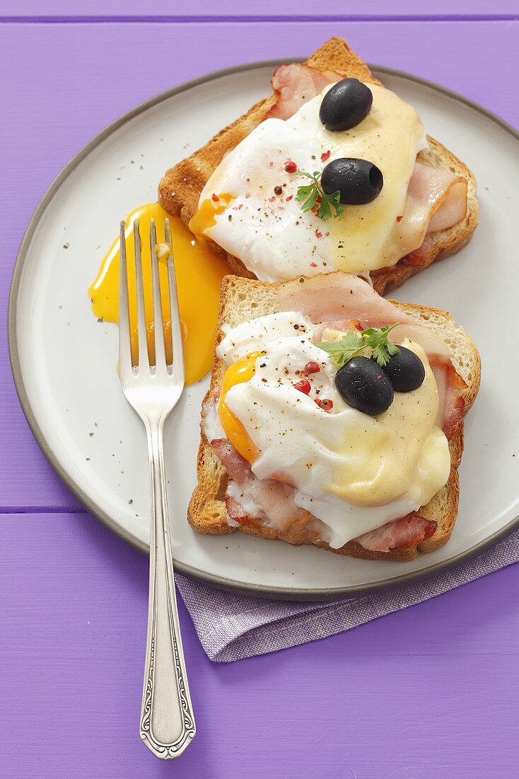 Ham, poached egg and cheese on toast with olives