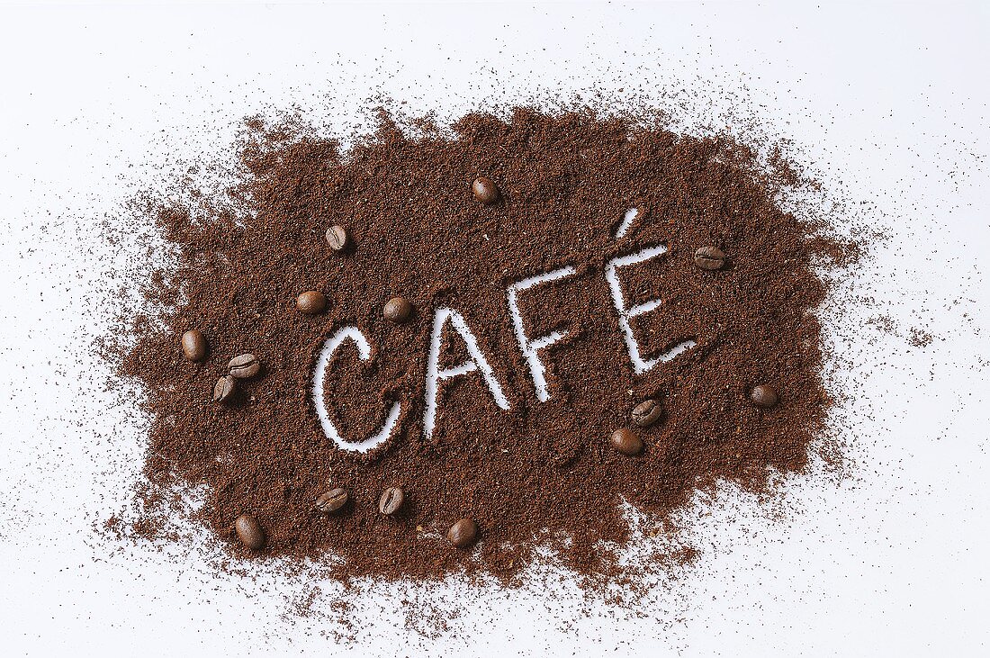 The word CAFE written in ground coffee