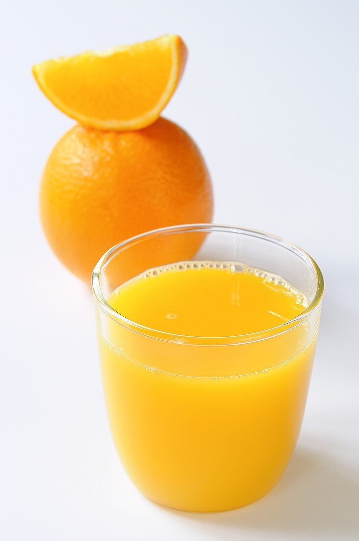 Glass of orange juice, orange and orange wedge