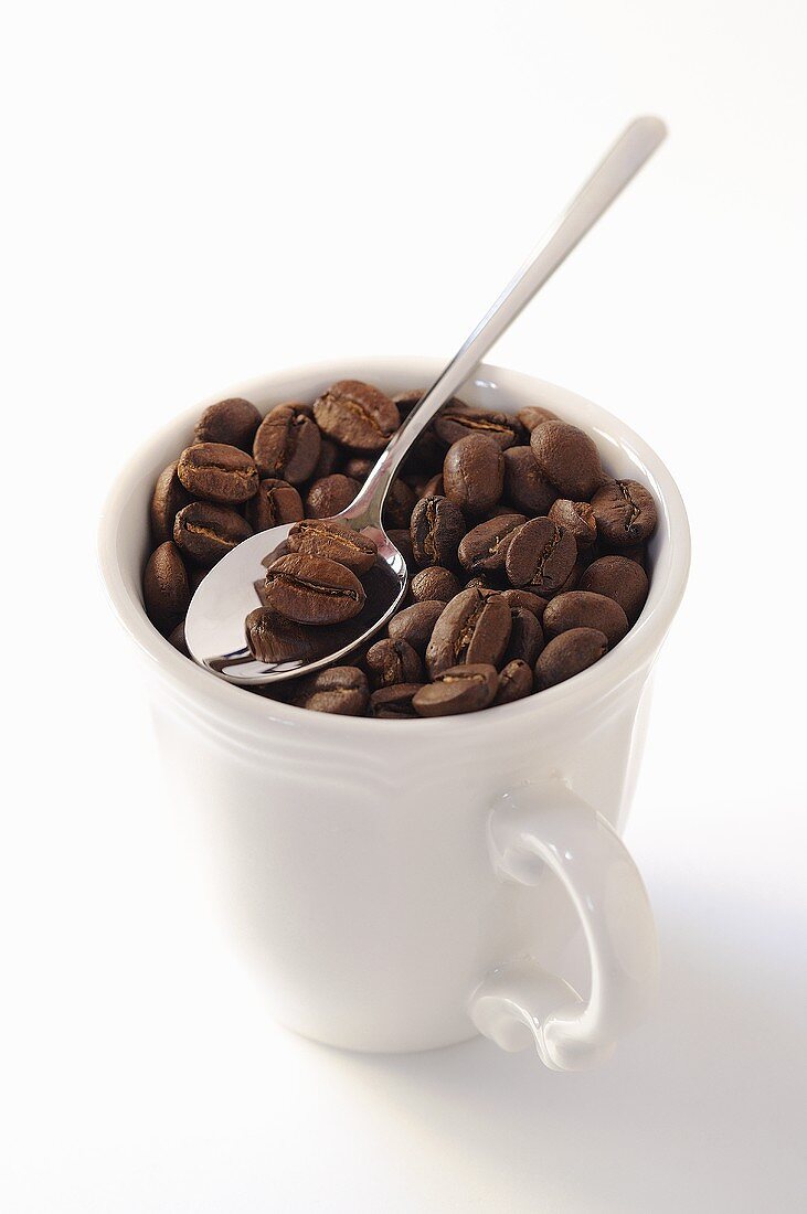 Kaffeebohnen in Tasse mit Löffel