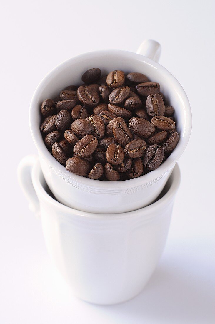 Kaffeebohnen in gestapelten Tassen