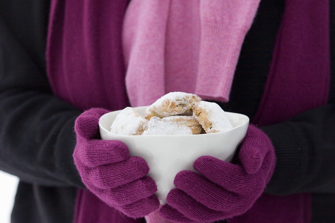 Hände halten Schälchen mit Stollengebäck