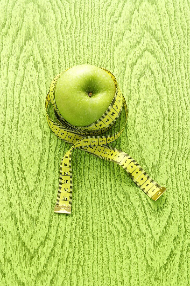 A green apple with a tape measure