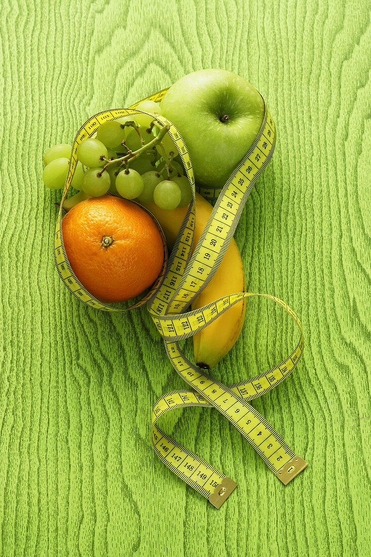 Verschiedene Früchte mit einem Massband