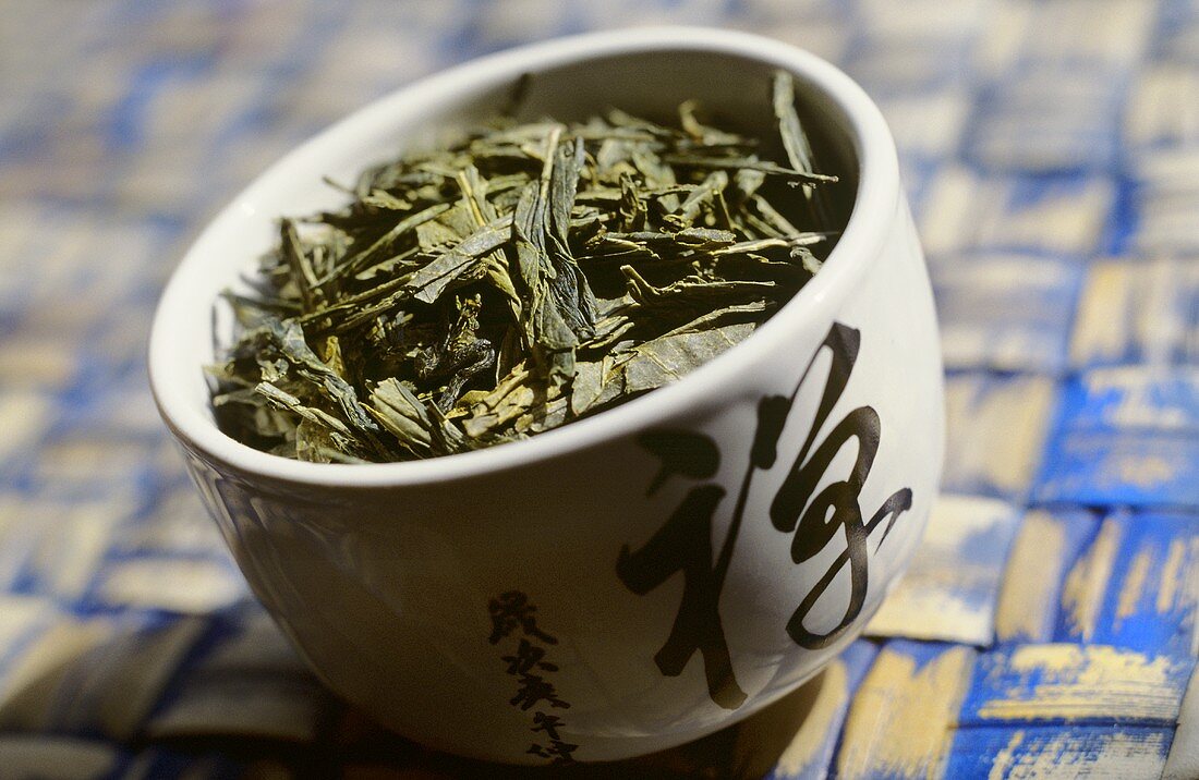 Dry (unused) green tea in a small bowl