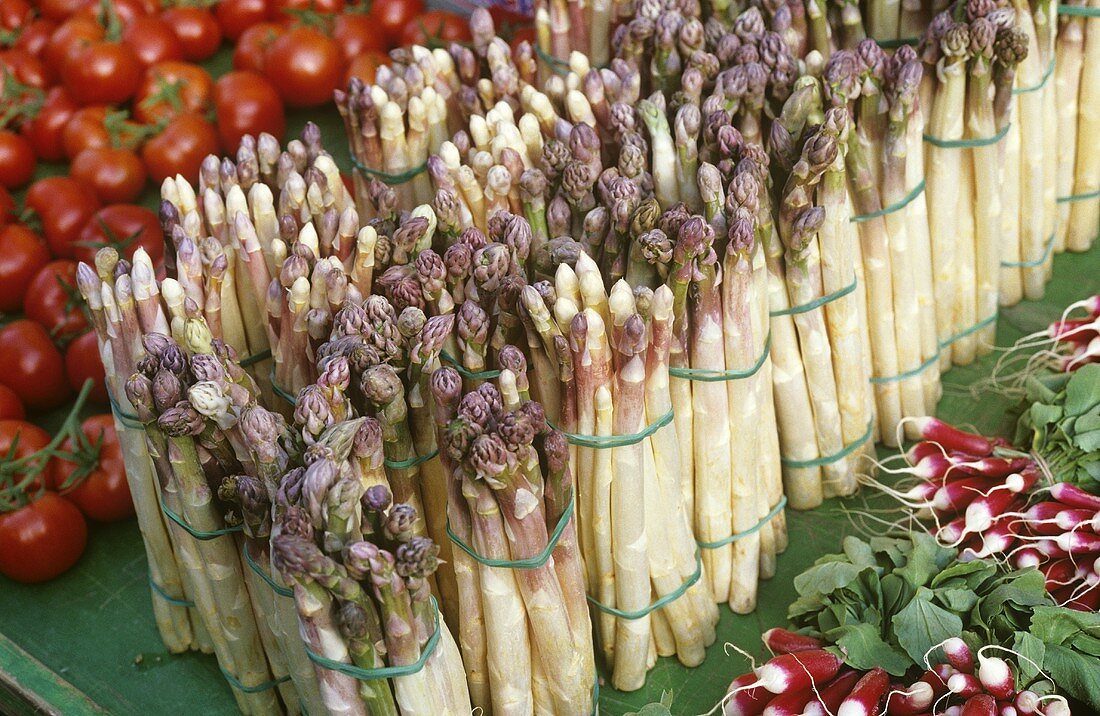 Asparagus, tomatoes and radishes on a market stall