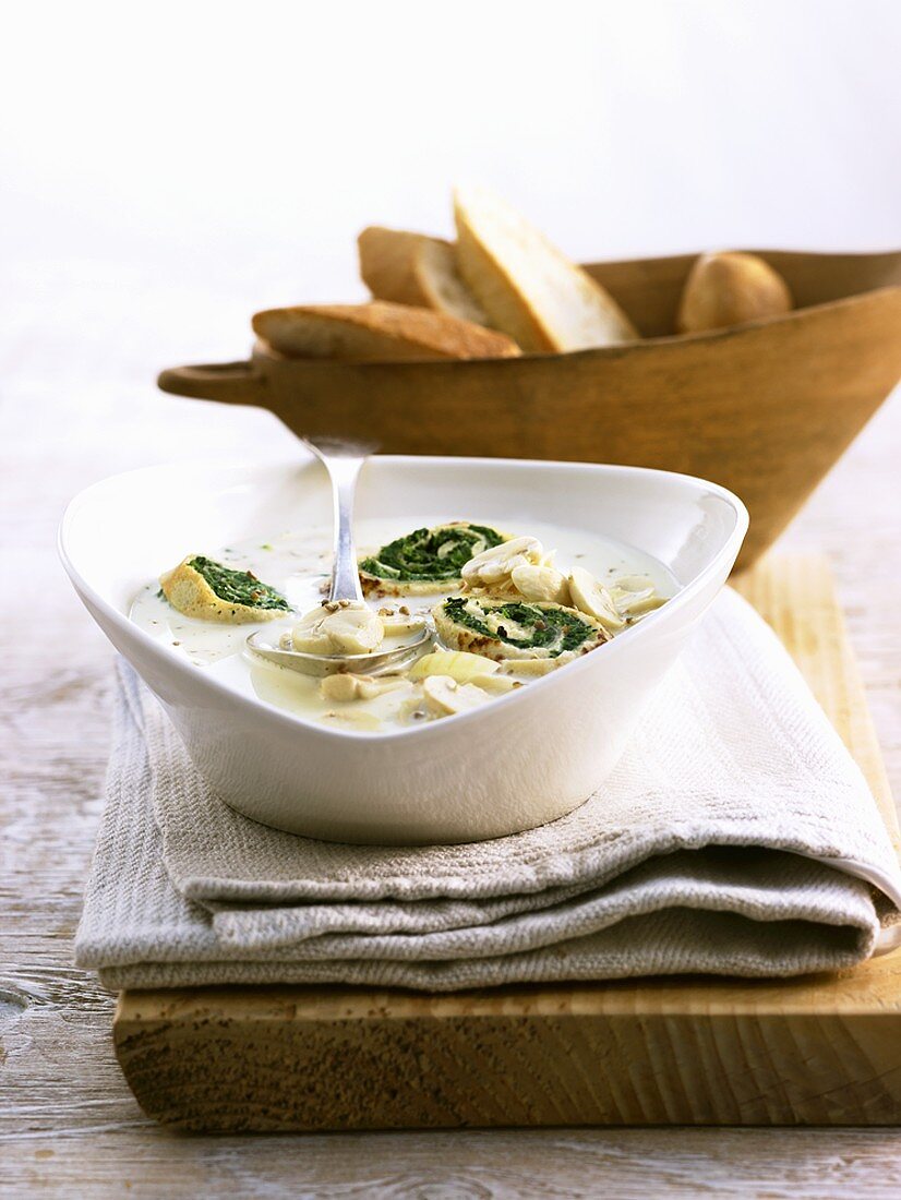 Creamed mushroom soup with spinach crepe rolls