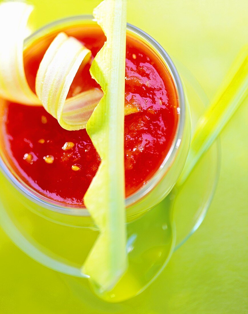 Gazpacho mit Stangensellerie auf grünem Untergrund